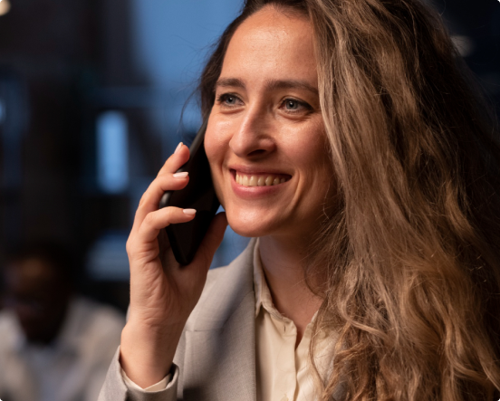 Imagem de uma mulher sorrindo, falando no celular